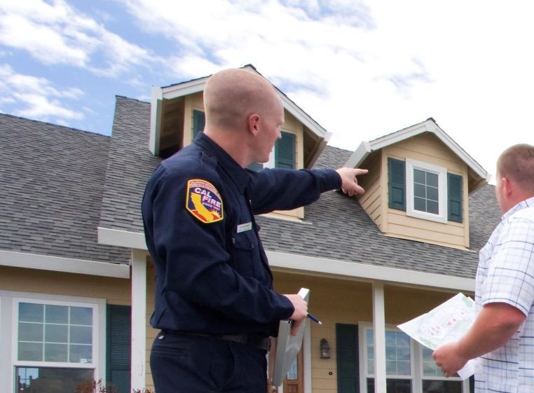 A defensible space inspector points out an issue to a home owner