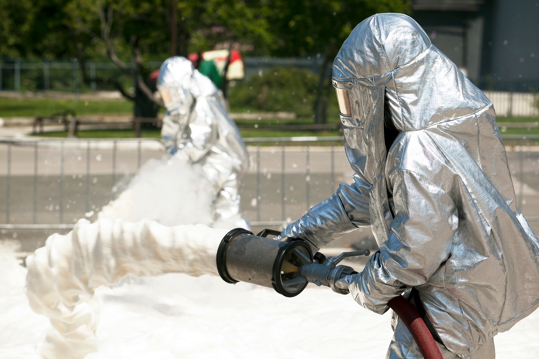 HAZMAT operators spray firefighting foam