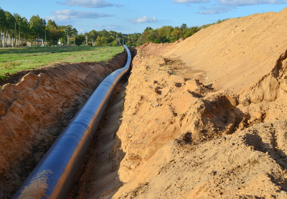 A dug trench in the ground for the installation of industrial pipeline