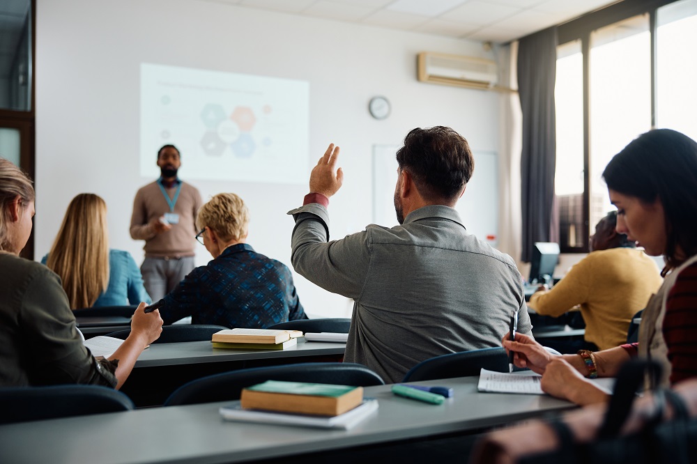 A student raises his hand during a college course